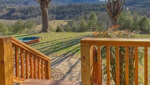 Eine Holzterrasse mit Blick auf eine bewaldete Landschaft und Berge im Hintergrund.