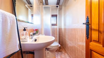 Un baño con lavabo, inodoro y zona de ducha.