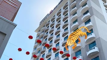 A multi-story building with balconies and red lanterns.