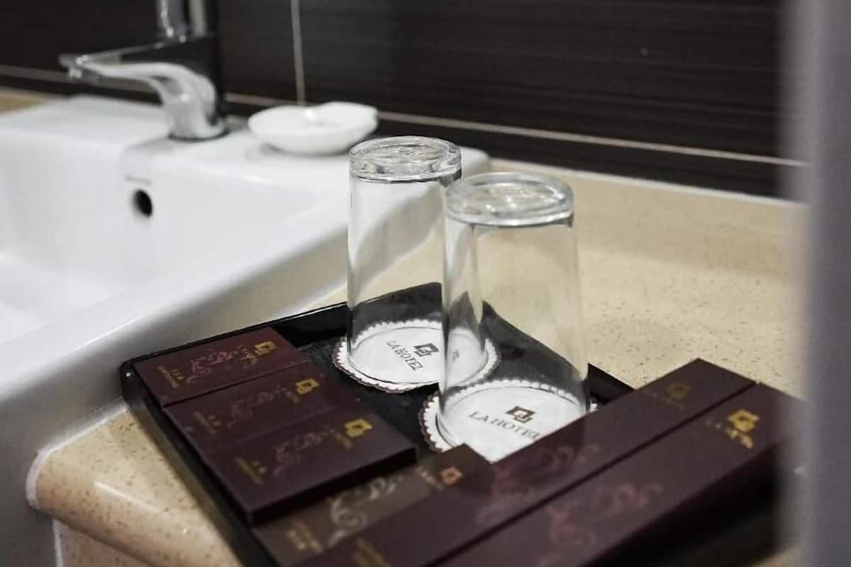 Une salle de bain avec un lavabo blanc, un miroir et un mur décoratif.
