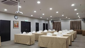 A conference room with multiple tables, white chairs, a projector, and a clock on the wall. - LA Hotel Tawau (Tawau)