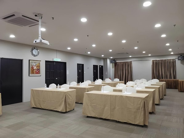 A conference room with multiple tables, white chairs, a projector, and a clock on the wall. - LA Hotel Tawau (Tawau)