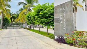 A paved pathway leading to a building with a sign reading "PELADA PIKIN". - Casa en privada frente a la alberca by PartnerHost (Mazatlán)