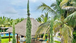 A resort with a pool, outdoor seating, and thatched-roof structures. - Casa en privada frente a la alberca by PartnerHost (Mazatlán)