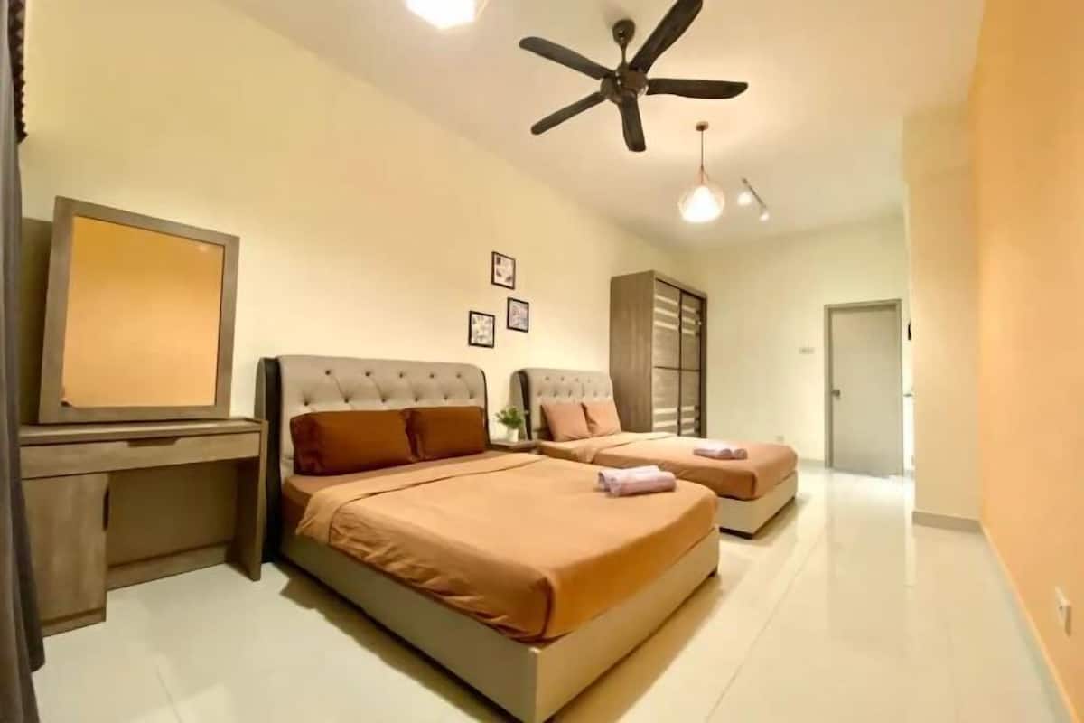 Habitación de hotel con dos camas, un escritorio, un ventilador de techo y un espejo grande.