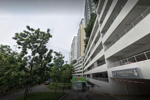 A multi-story parking garage with a sign for 'Parking Training' and a green truck parked in the lot. - Puchong Setiawalk Penthouse for 14 Pax Iconique (Puchong)