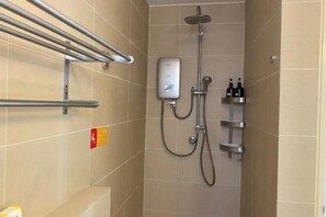 A shower area with a handheld showerhead, a wall-mounted control panel, and a shelf with toiletries. - Puchong Setiawalk Penthouse for 14 Pax Iconique (Puchong)