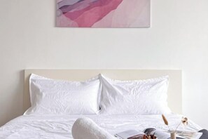 A bed with white bedding, a pillow, and a magazine on the side. - Da Men Subang Jaya USJ by Iconique (Subang Jaya)