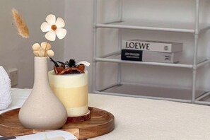 A decorative arrangement with a vase, a candle, and a book titled "LOEWE" on a shelf. - Da Men Subang Jaya USJ by Iconique (Subang Jaya)