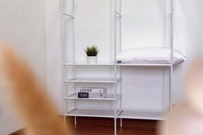 A white metal shelving unit with a small potted plant and a book titled 'LOEWE'. - Da Men Subang Jaya USJ by Iconique (Subang Jaya)