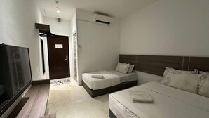 Une chambre d’hôtel équipée d’un lit, d’une télévision, d’une armoire et d’un appareil de climatisation.