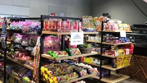 Un rayon d’épicerie où sont exposés divers produits emballés, notamment des en-cas et des boissons.