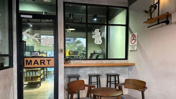 Un comptoir avec une porte en verre, des chaises en bois et un bar avec des tabourets.