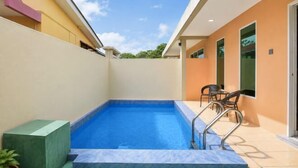 A swimming pool with steps, a potted plant, and a chair. - Collection O Langkawi near pantai cenang formerly tokman inn (Langkawi)