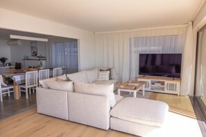 A modern living room with a sofa, coffee table, and a television.
