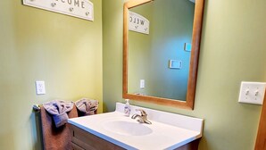 A bathroom with a sink, mirror, towel rack, and a welcome sign. - Catchin Crickets near Pictured Rocks and ATV Trails!  (Shingleton)