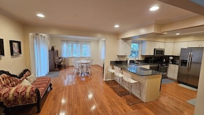 A spacious living area with a piano, a dining table with chairs, and a kitchen with modern appliances. - Spacious and Family Friendly 6-bedrooms house in delightful Silver Spring. (Silver Spring)