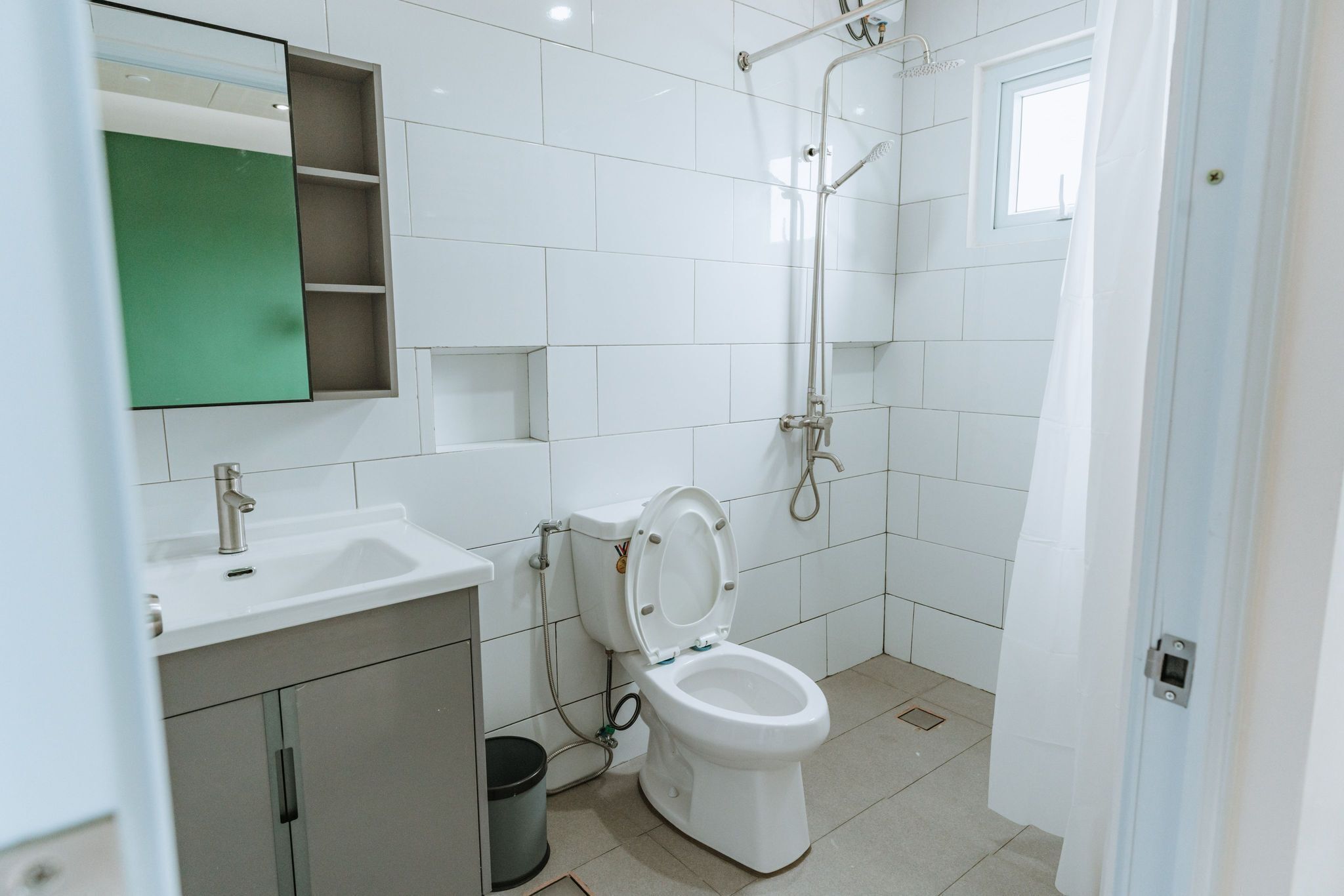 A modern bathroom with a toilet, sink, and shower.