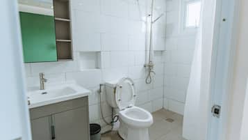 Une salle de bain moderne équipée de toilettes, d’un lavabo et d’une douche.