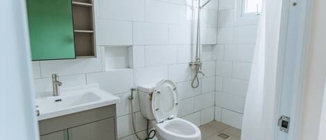 A modern bathroom with a toilet, sink, and shower.