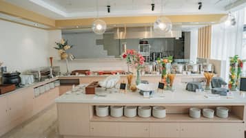 Una cocina moderna con una isla central, encimeras blancas y diversos electrodomésticos.