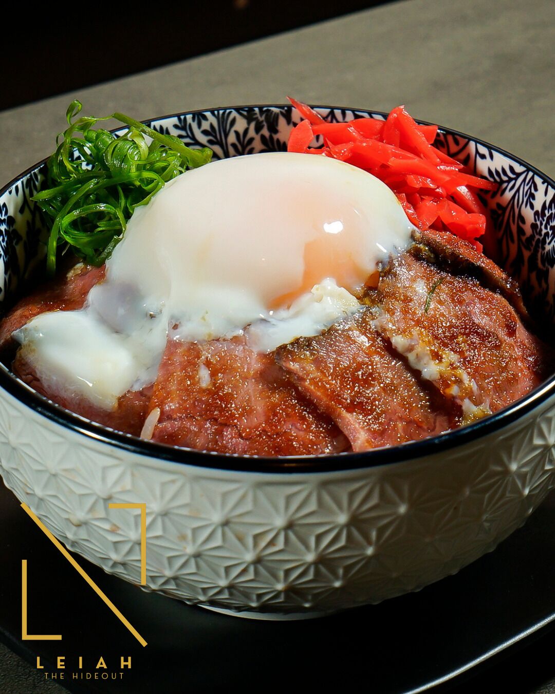 A bowl of food with a poached egg, slices of meat, and vegetables.