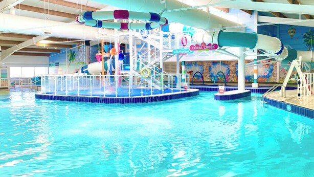 An indoor water park with multiple slides and a dolphin-themed area. - Luxury Chichester caravan  Seaside Retreat (Chichester)