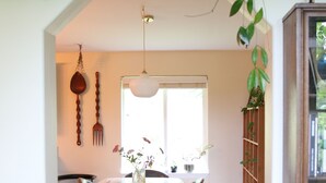 Un espace repas comprenant une table et des chaises, un luminaire suspendu et des plantes en pot.