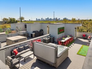 A rooftop patio with outdoor seating, a hot tub, and a city skyline view. - Rooftop + Hot Tub + Game Room (Nashville)