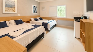 A hotel room with two beds, a kitchenette, a TV, and artwork on the walls. - Marmeu Enseada (Guarujá)