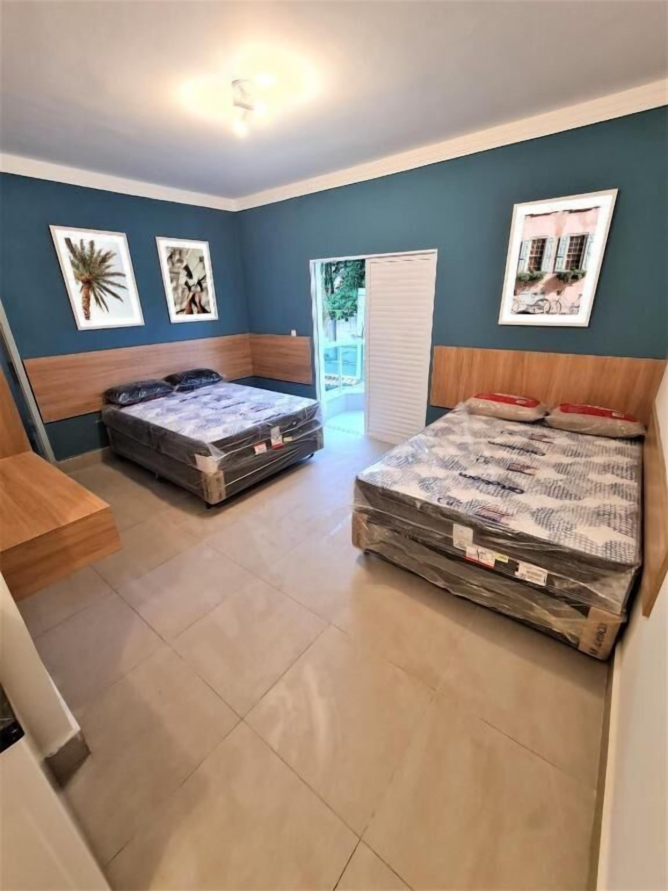 Un dormitorio con dos camas, un cabecero de madera y una puerta que da a un balcón.