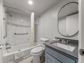 Bañera con ducha, toallas, jabón, papel higiénico