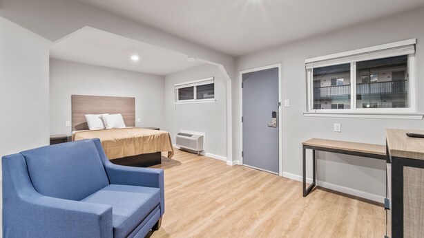 Een moderne slaapkamer met een bed, een bureau en een stoel.