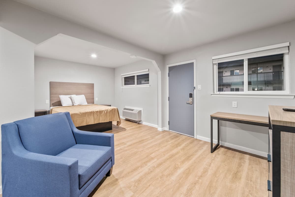 A modern bedroom with a bed, a desk, and a chair.