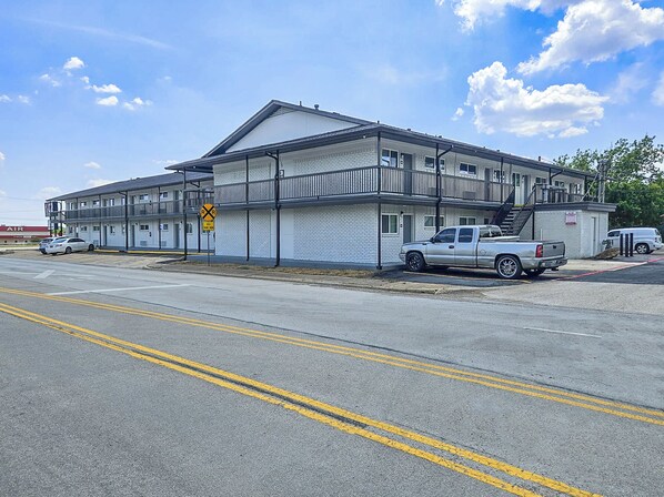 A motel with a two-story structure, a parking lot, and a visible 'No Parking' sign.