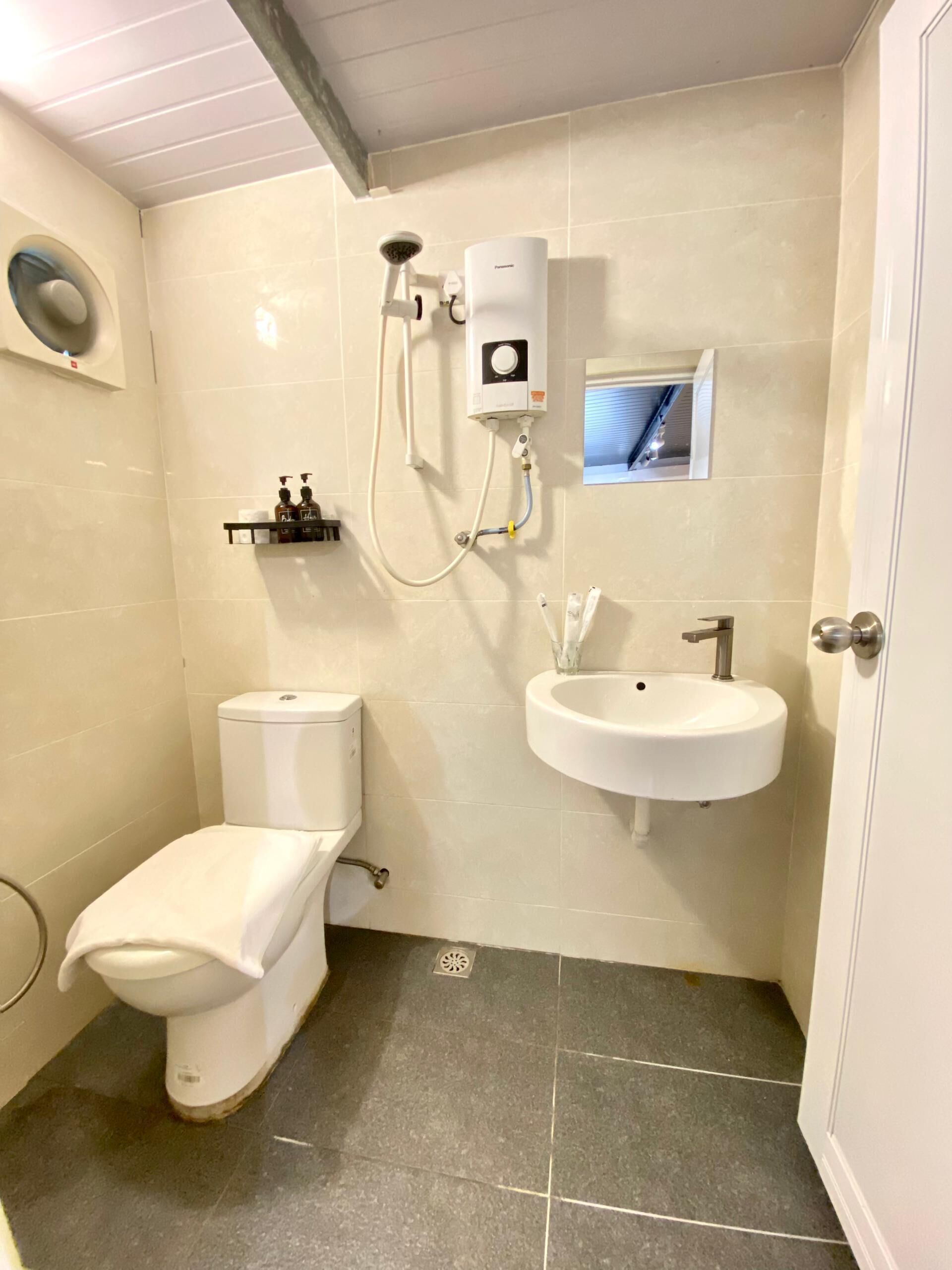 A bathroom with a toilet, a sink, and a shower.