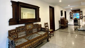 A spacious lobby with a large ornate wooden bench, a reception desk, and a staircase leading to upper floors. - Bayu Bayu Hotel by Soft Loft (George Town)
