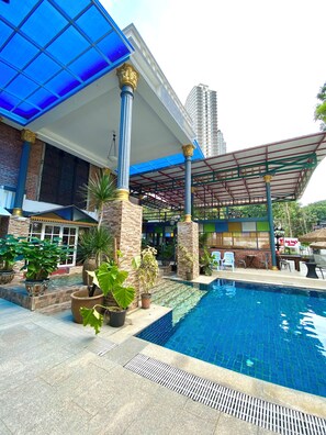 A pool area with a covered seating area, potted plants, and a view of a building with large windows. - Bayu Bayu Hotel by Soft Loft (George Town)