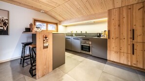 Une cuisine moderne avec des meubles en bois, un coin bar et une grande fenêtre.