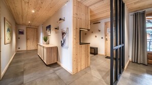 Un intérieur moderne avec des lambris en bois, un comptoir d’accueil, des œuvres d’art et une grande fenêtre agrémentée de rideaux.
