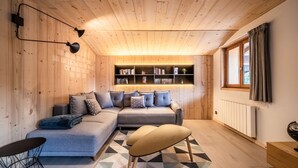 Une pièce chaleureuse avec un canapé d’angle, une petite table et un coin lecture.