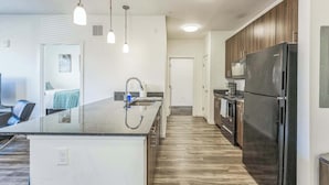 A modern kitchen with a central island, stainless steel appliances, and pendant lighting. - Big Flat + 2 min to UM + 95 Walkscore (Missoula)