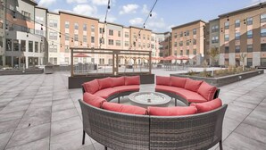 A rooftop patio with a circular seating area, a glass enclosure with tables, and a view of adjacent buildings. - Big Flat + 2 min to UM + 95 Walkscore (Missoula)
