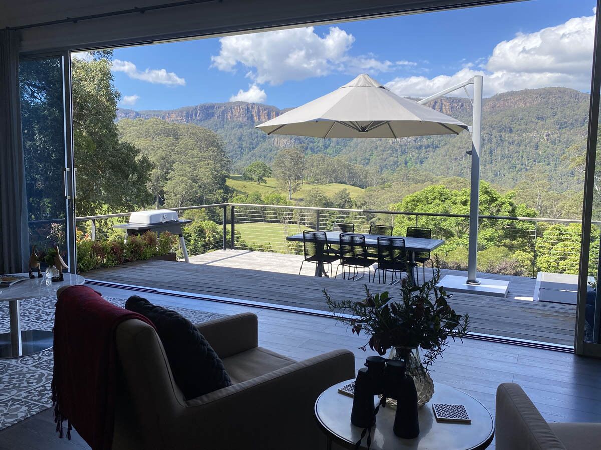 A modern living room with a large window overlooking a scenic mountain landscape.