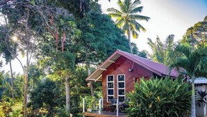 A small wooden house with a porch, surrounded by lush tropical vegetation. - Timba Garden Semporna Free Town / Jetty Transport (Semporna)