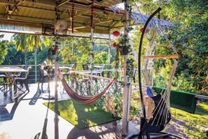 An outdoor seating area with a hammock, tables, and chairs. - Timba Garden Semporna Free Town / Jetty Transport (Semporna)