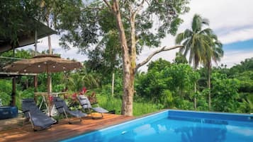A poolside area with lounge chairs and a wooden deck.