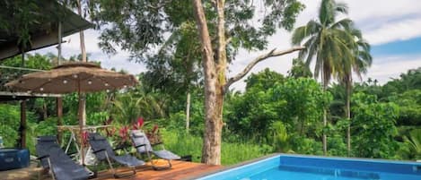 A poolside area with lounge chairs and a wooden deck.