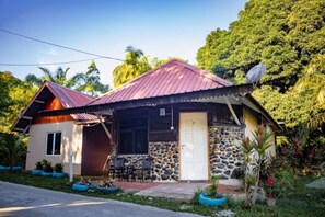 A single-story house with a stone foundation, a red roof, and a satellite dish. - Timba Garden Semporna Free Town / Jetty Transport (Semporna)