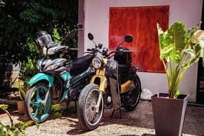 Two motorcycles parked in front of a building with a red door. - Timba Garden Semporna Free Town / Jetty Transport (Semporna)